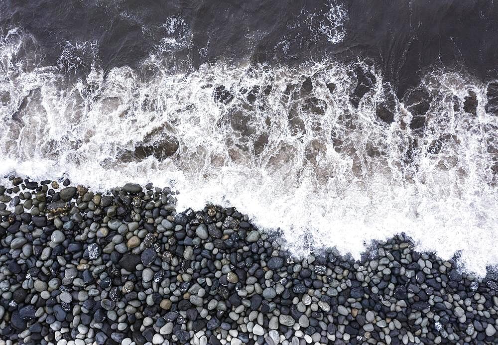 Drone shot, surf with big round stones on the beach of Rocha da Relva, Sao Miguel Island, Azores, Portugal, Europe