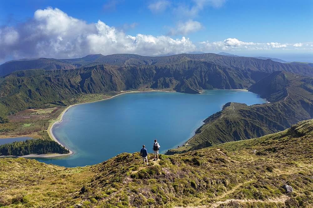 Hikers at the summit of Pico Barrosa with view to the crater lake Lagoa do Fogo, Sao Miguel Island, Azores, Portugal, Europe