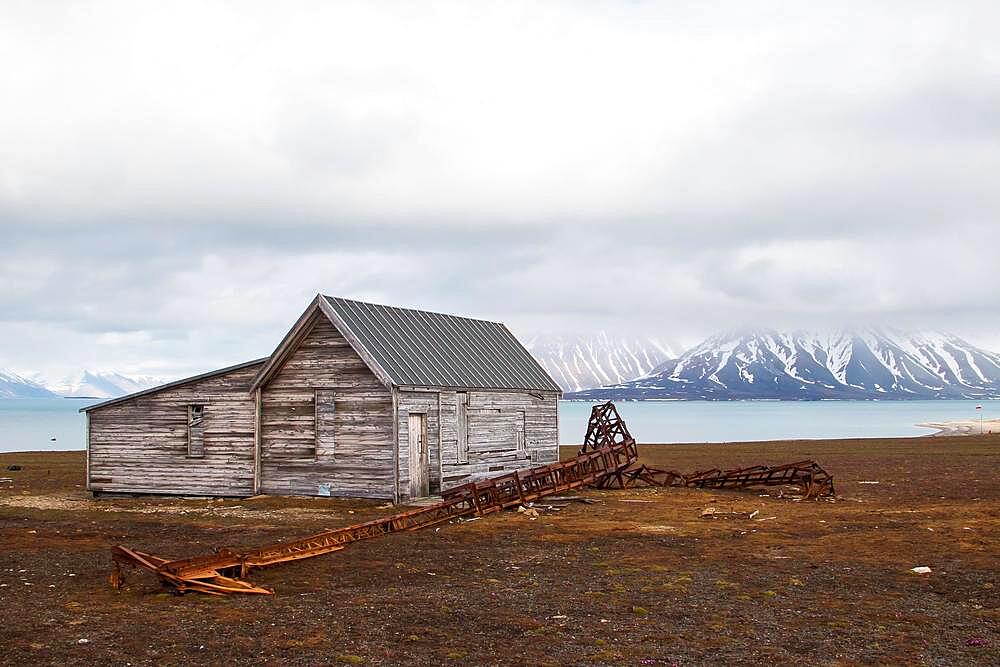 Former mining station Calypsobyen, wooden barrack and dilapidated metal mast, view of Bellsund, Spitsbergen Island, Norway, Europe