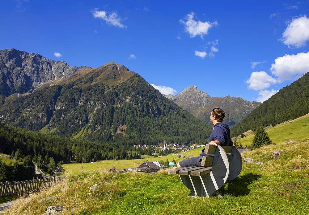 Stubai Alps, hiker sitting on a bench near the mountaineering village of Sankt Sigmund im Sellrain, Tyrol, Austria, Europe