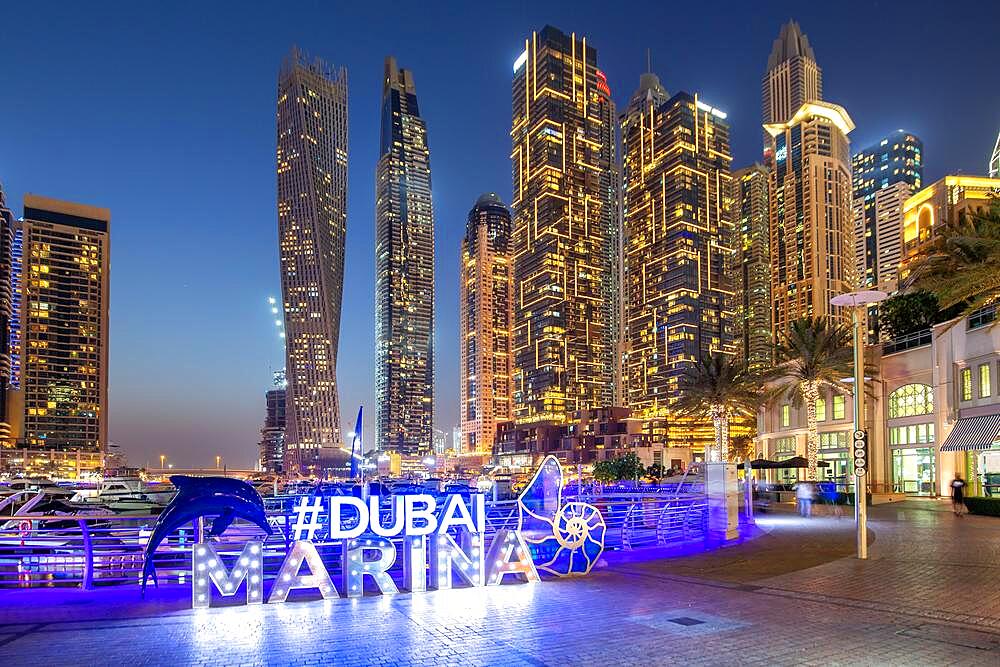 Dubai Marina Logo and Harbour Skyline Architecture Luxury Holiday in Arabia by Night in Dubai, United Arab Emirates, Asia