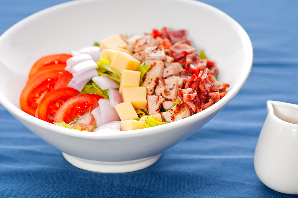 Fresh classic caesar salad over blue tablecloth close up, healthy meal