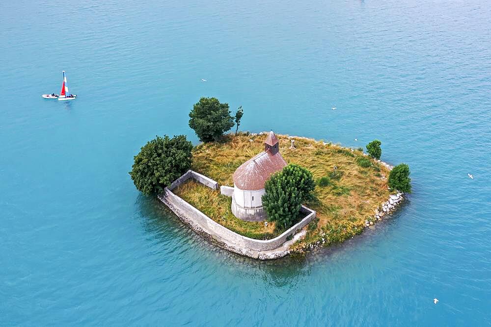 Drone shot, drone photo of the chapel Saint Michel de Pruniers in the lake Lac de Serre Poncon with view of the surrounding mountains, Departement Hautes-Alpes, France, Europe