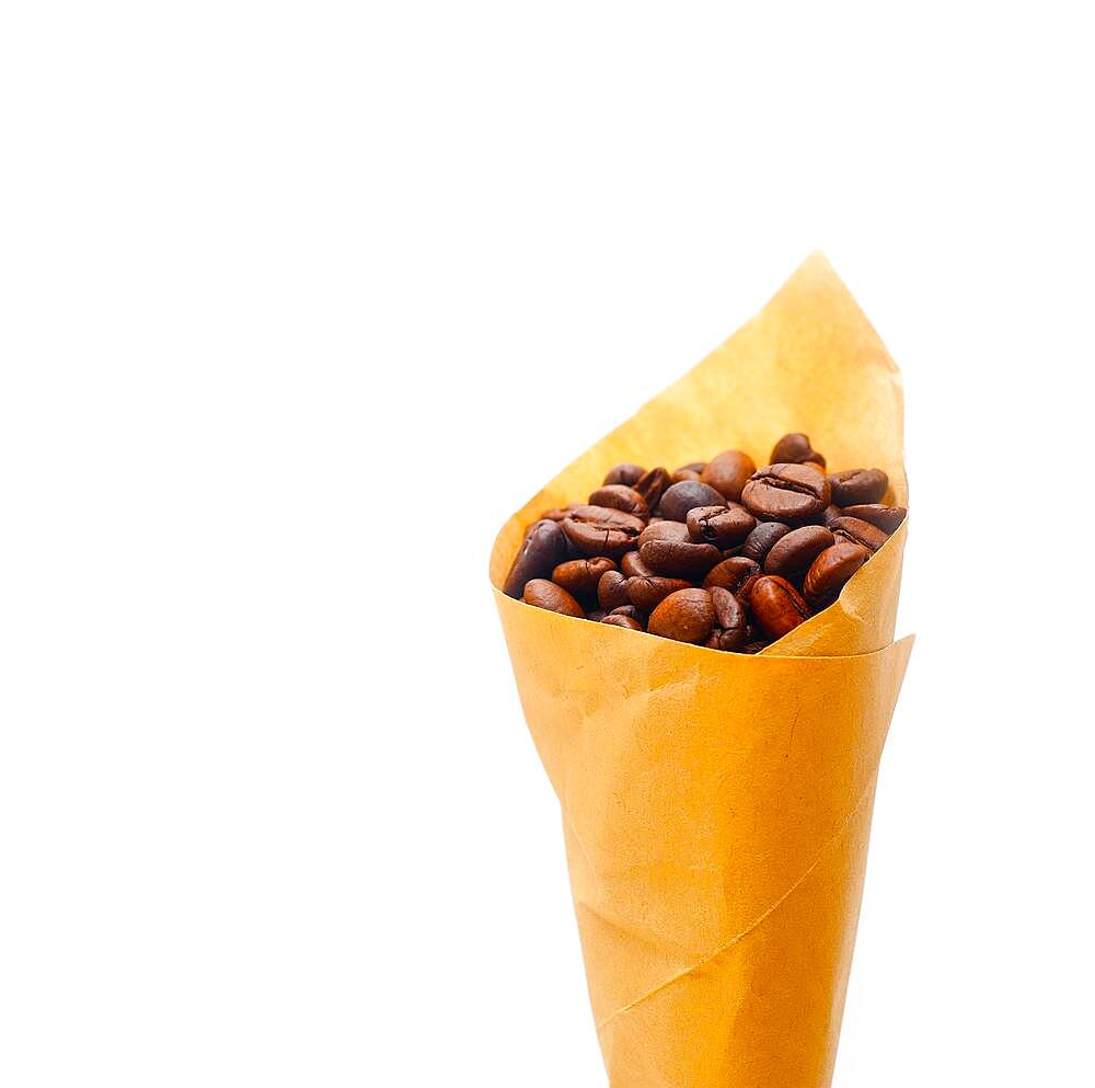 Espresso coffee beans on a paper cone cornucopia over white background