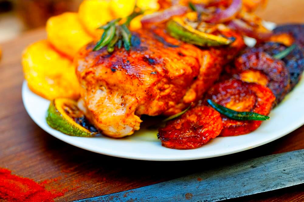 Roasted grilled BBQ chicken breast with herbs and spices rustic style