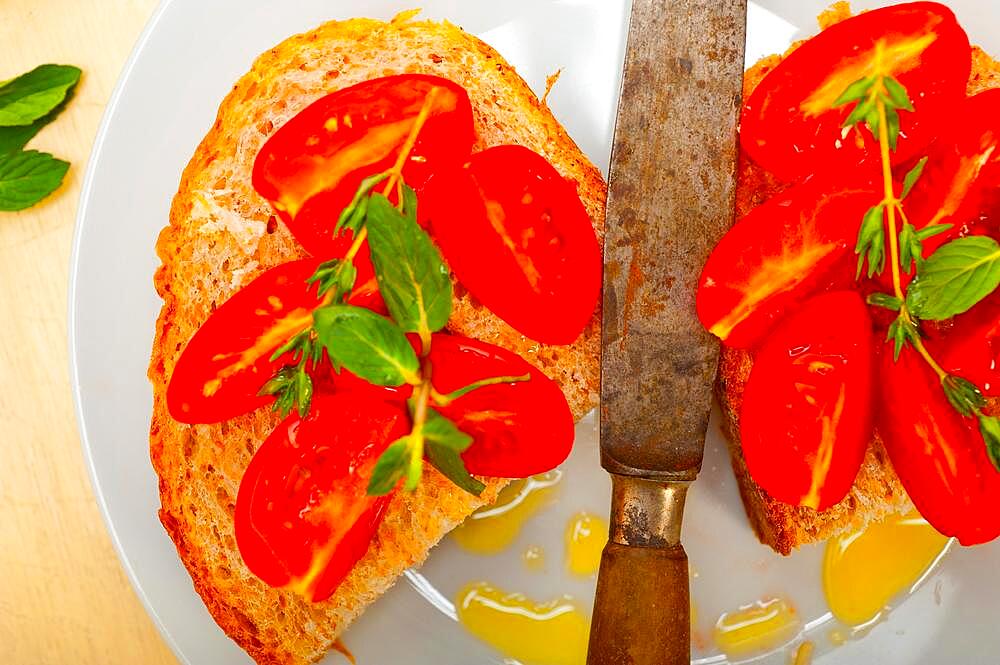 Italian tomato bruschetta with thyme and mint leaves