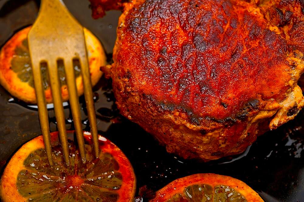 Pork chop seared on iron skillet with lemon and spices seasoning