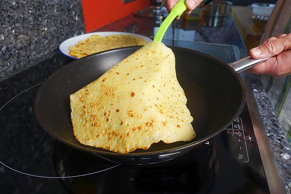 Swabian cuisine, pancakes, frying flaedle in the pan, spatula, preparing spinach cake spoon style, Swabian speciality, men's hands, Germany, Europe