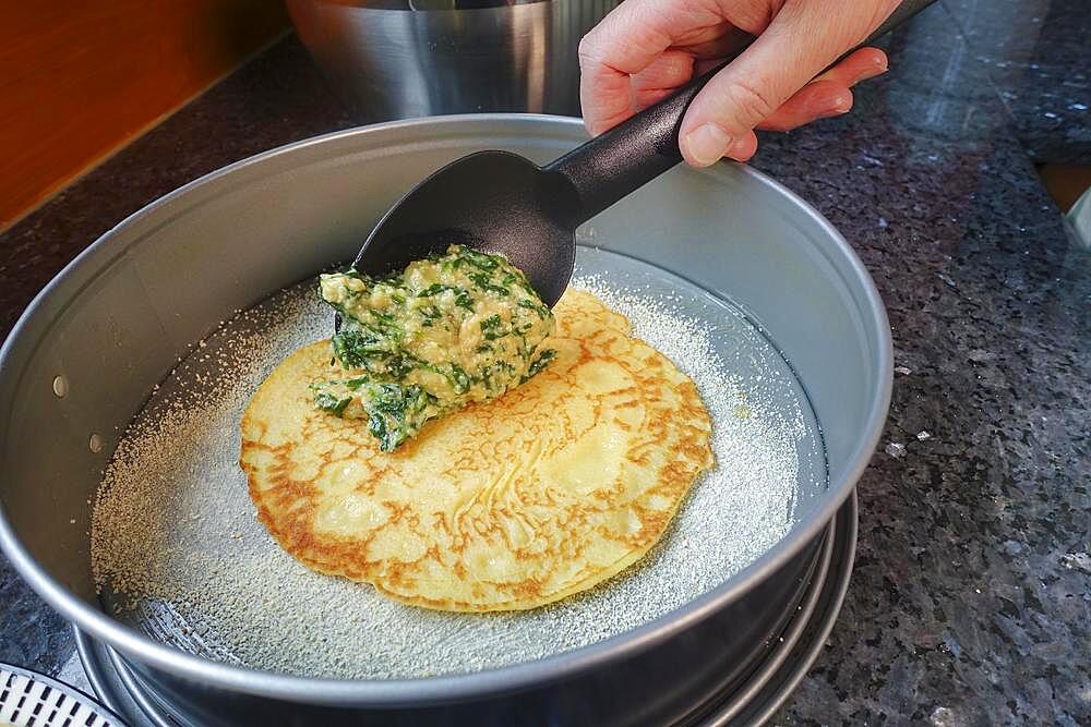 Swabian cuisine, pancake, pancake in the form layer with spinach mixture, springform, cake form, ladle, preparation spinach cake in the manner of the spoon, Swabian speciality, man's hand, Germany, Europe