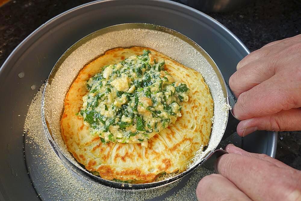 Swabian cuisine, pancakes, pancake layers with spinach mixture, springform pan, cake tin, preparing spinach cake spoon style, Swabian speciality, men's hands, Germany, Europe