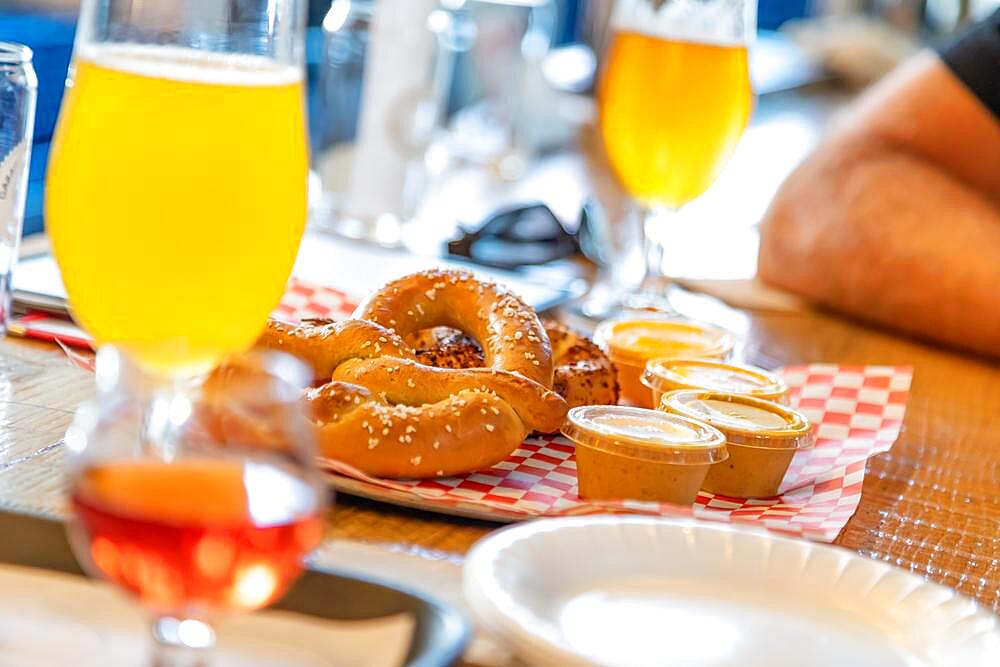 Abstract of small glass of micro brew beers and warm pretzels on bar