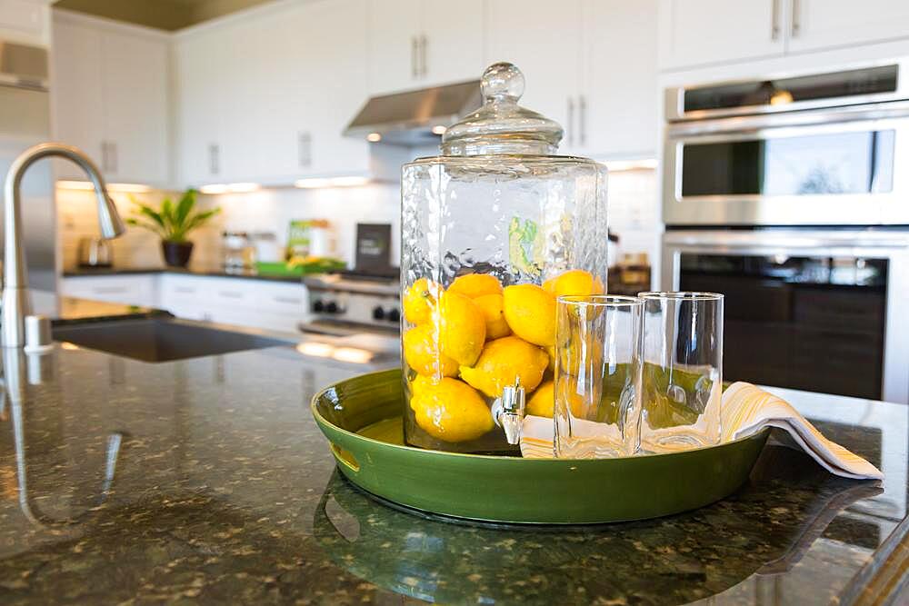 Abstract of interior kitchen counter with lemon filled pitcher and drinking glasses