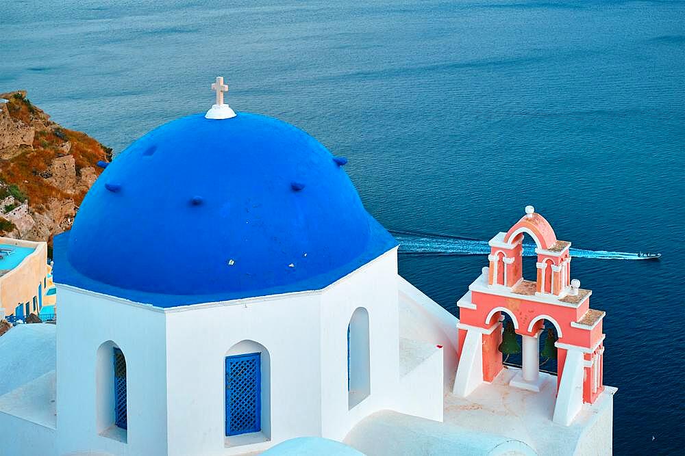 Famous view from viewpoint of Santorini Oia village with blue dome of whitewashed greek orthodox Christian church of traditional greek architecture, Oia town, Santorini island, Greece, Europe