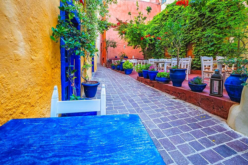 Street cafe in scenic picturesque streets of Chania venetian town with coloful old houses, Chania greek village in the morning, Chanica, Crete island, Greece, Europe