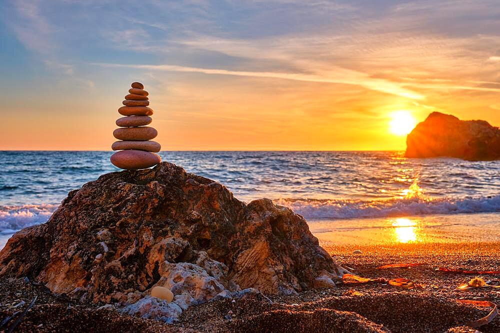 Concept of balance and harmony, Cairn stack of stones pebbles cairn on the beach coast of the sea in the nature on sunset, Meditative art of stone stacking