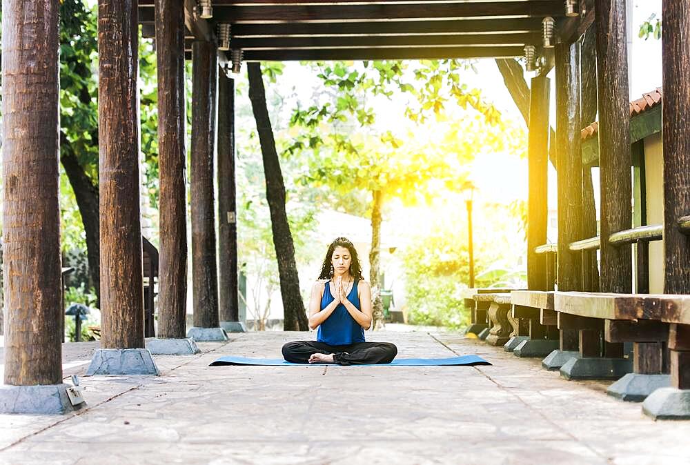 A girl sitting doing meditation yoga outdoors, Woman doing yoga outdoors, a young woman doing yoga with closed eyes