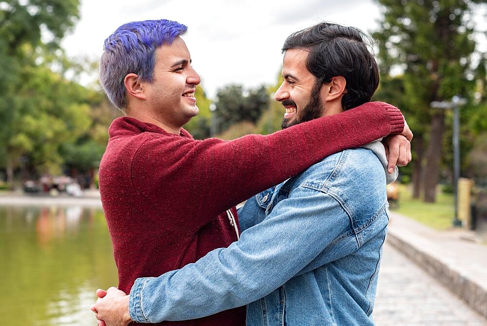 Gay male couple hugging and looking at each other