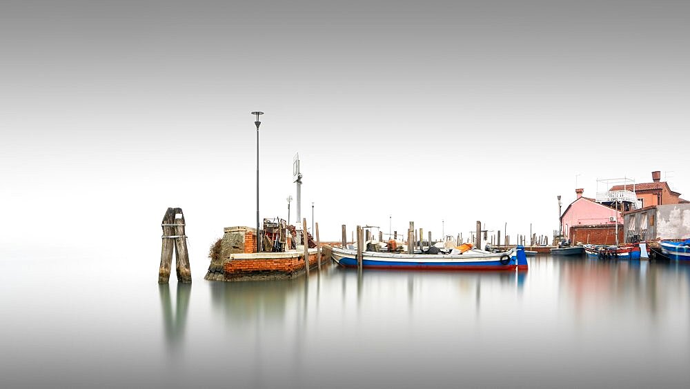 Classic harbour view of the small port of Burano in the fog in Italy