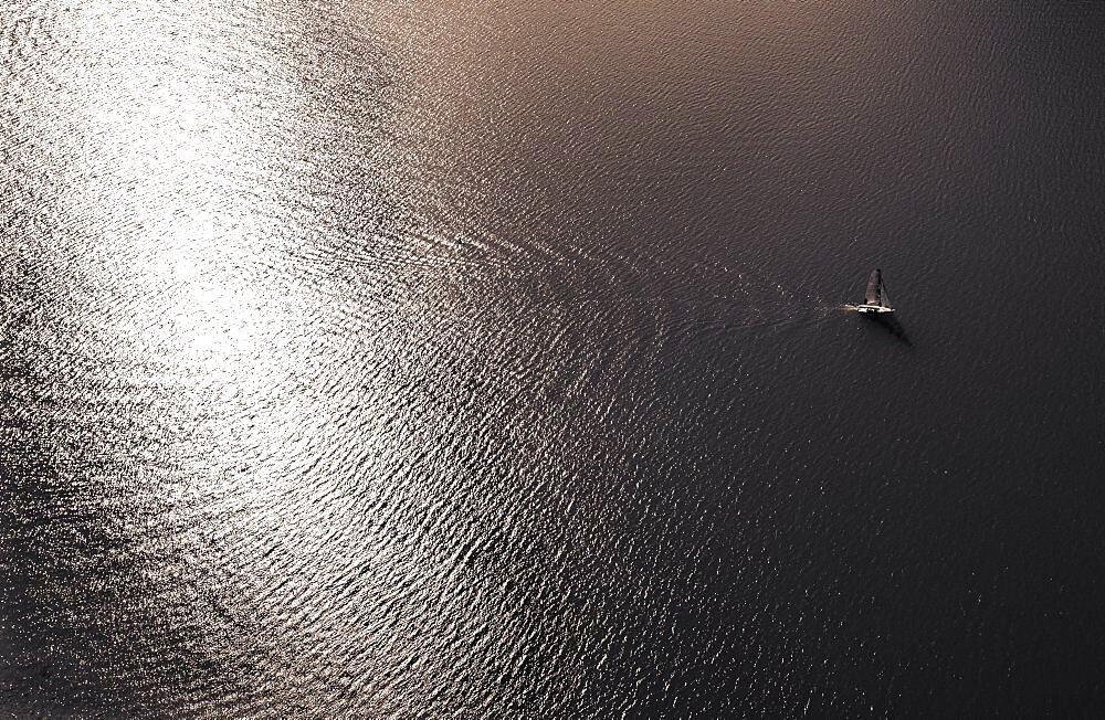 Drone shot, sepia colours, sailboat from above at the lake in backlight with water reflection, Mondsee, Salzkammergut, Upper Austria, Austria, Europe