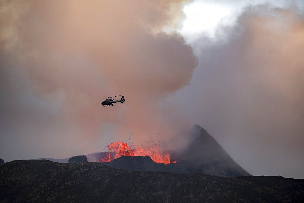 Helicopter flying over smoking active volcanic crater, glowing lava, volcanic eruption, active table volcano Fagradalsfjall, Krysuvik volcanic system, Reykjanes Peninsula, Iceland, Europe