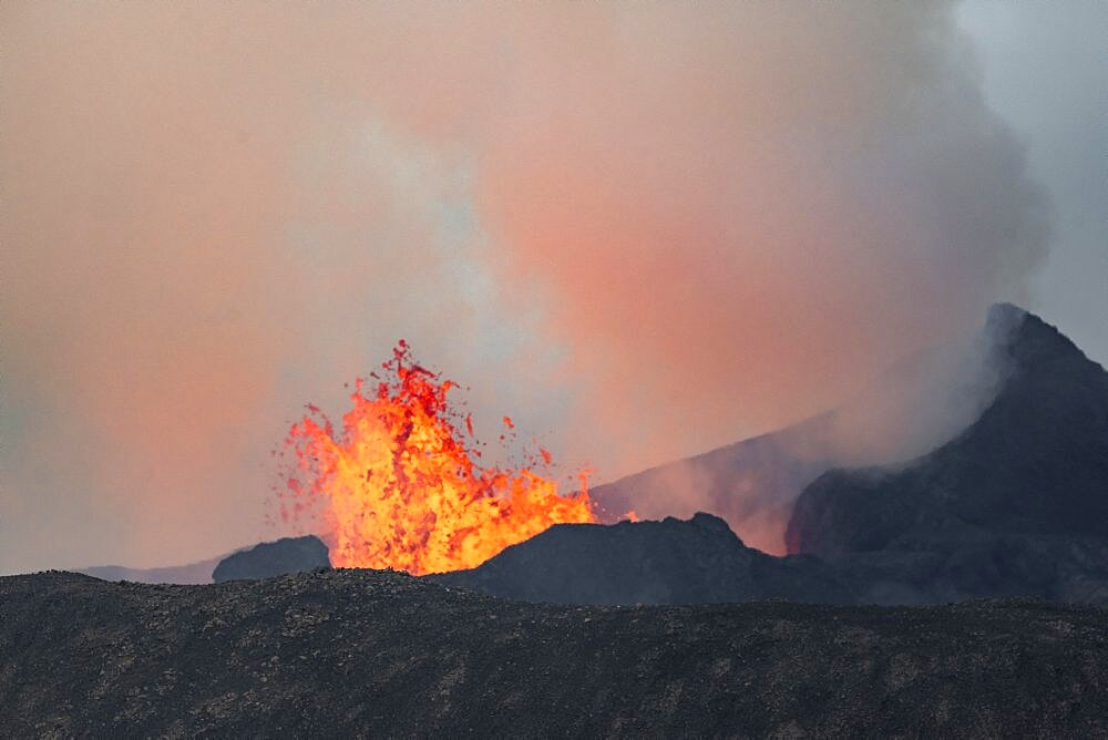 Smoking active volcanic crater, Glowing lava splashes over crater rim, Volcanic eruption, Active table volcano Fagradalsfjall, Krysuvik volcanic system, Reykjanes Peninsula, Iceland, Europe