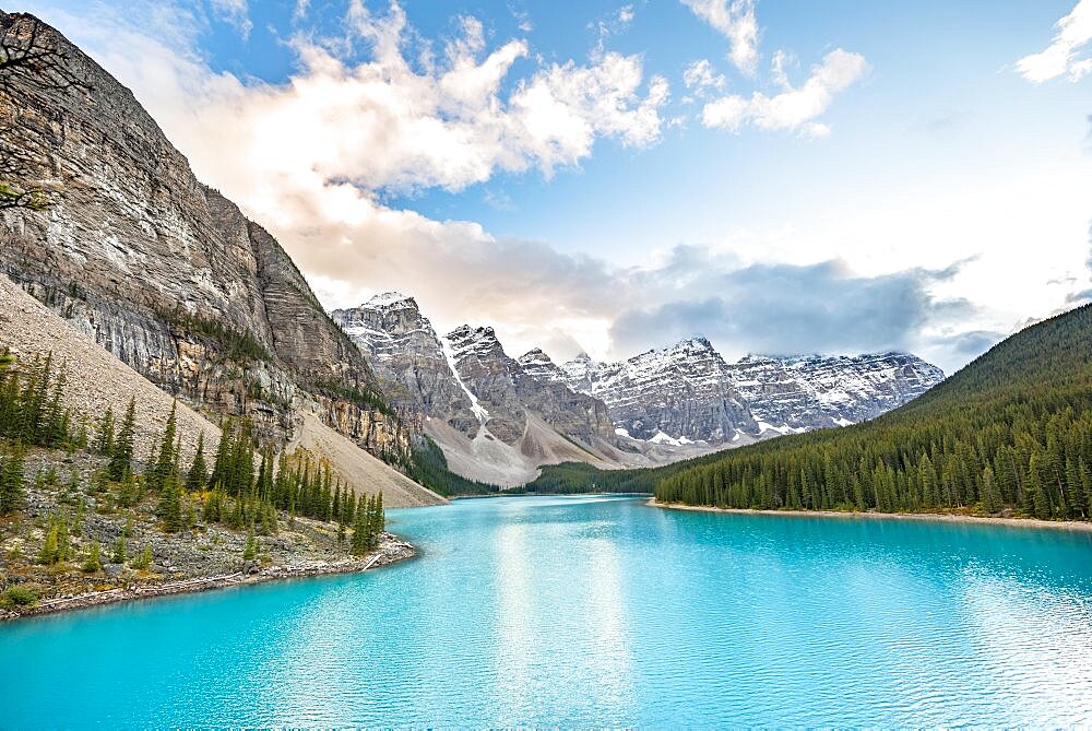 Clouds hanging between mountain peaks, mountain range behind turquoise glacial lake, sunrise, Moraine Lake, Valley of the Ten Peaks, Rocky Mountains, Banff National Park, Alberta Province, Canada, North America