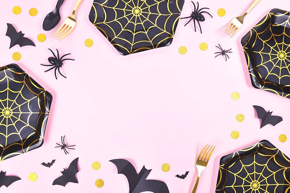 Halloween party frame with black and gold spider web plates, spiders and confetti on pink background