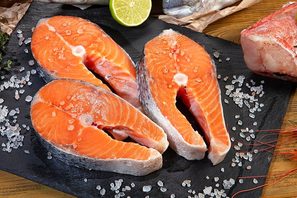 Red fish and limes on an old wooden desk