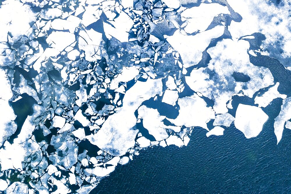 Droneview on a lake with floating ice sheet in the montain range Hemsedalfjell, Provinz Viken, Norway, Europe