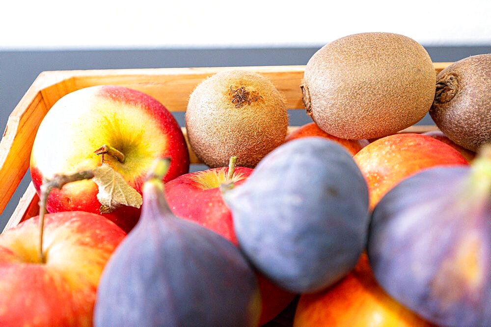 Apples, kiwi and fig in a wooden fruit basket as a healthy meal, Hanover, Lower Saxony, Germany, Europe