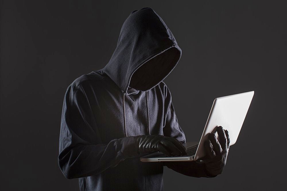 Side view of male hacker with gloves and laptop. Resolution and high quality beautiful photo