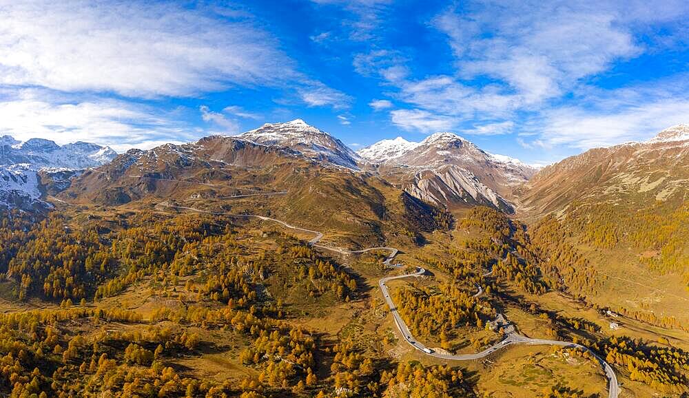 Aerial view over Val Poschiavo with its larch forests in autumn dress and the Bernina Pass road, Canton Graubuenden, Switzerland, Europe