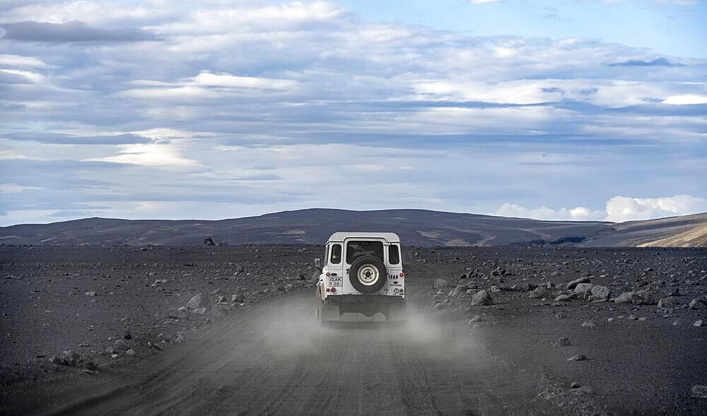 White Land Rover on a dirt road, volcanic landscape, barren landscape, Vatnajoekull National Park, Icelandic Highlands, Iceland, Europe