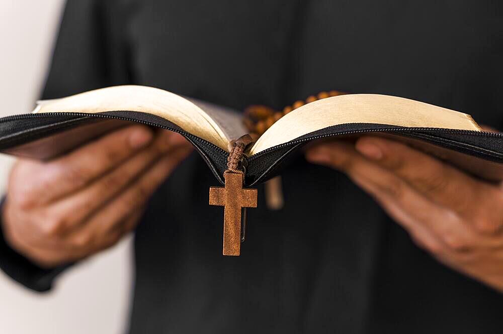 front view person with holy book rosary