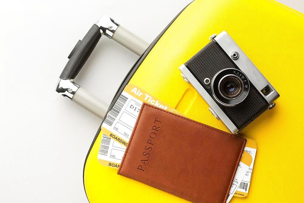 yellow luggage with camera passport