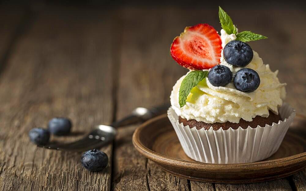 Front view view tasty cupcake with strawberry blueberry