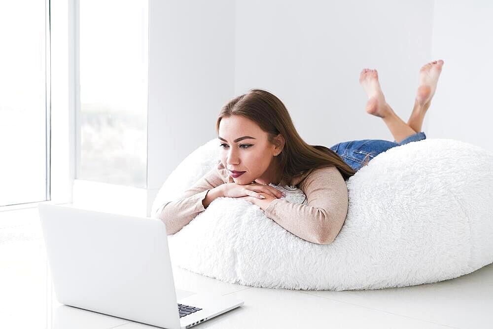 Woman using her laptop sitting bean bag