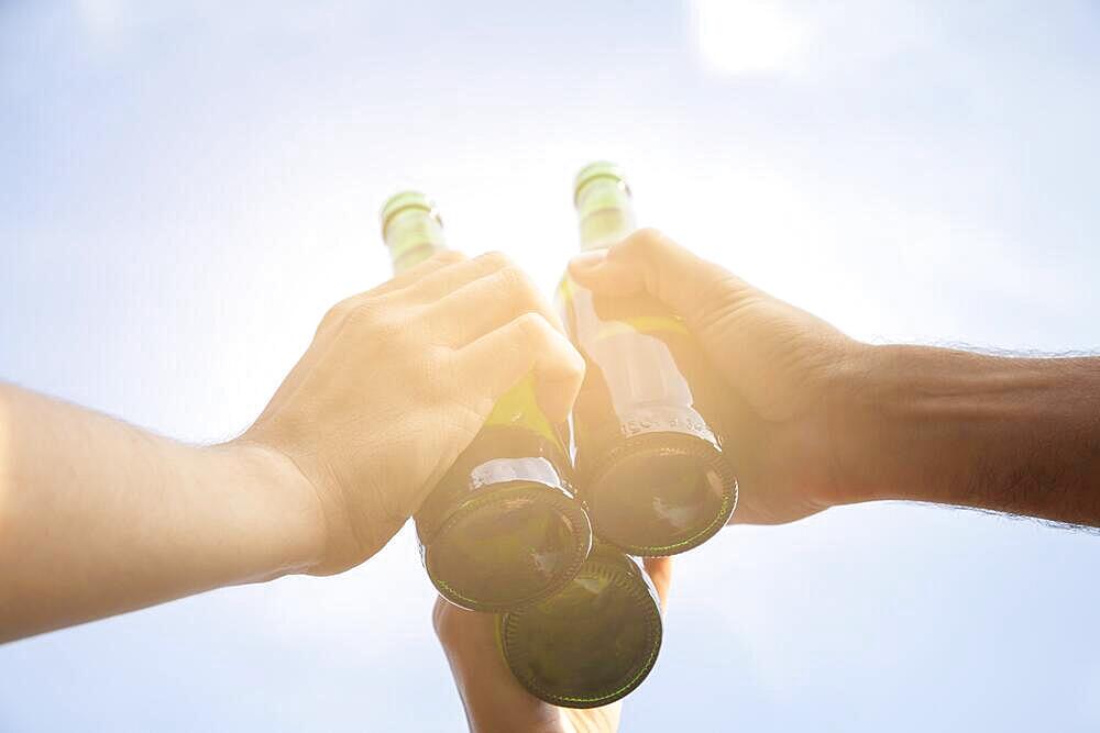 Toasting with beer bottles, Germany, Europe