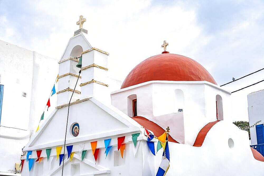 White Cycladic Greek Orthodox Church decorated with flags, alleys of the old town Chora, Mykonos Town, Mykonos, Cyclades, Greece, Europe