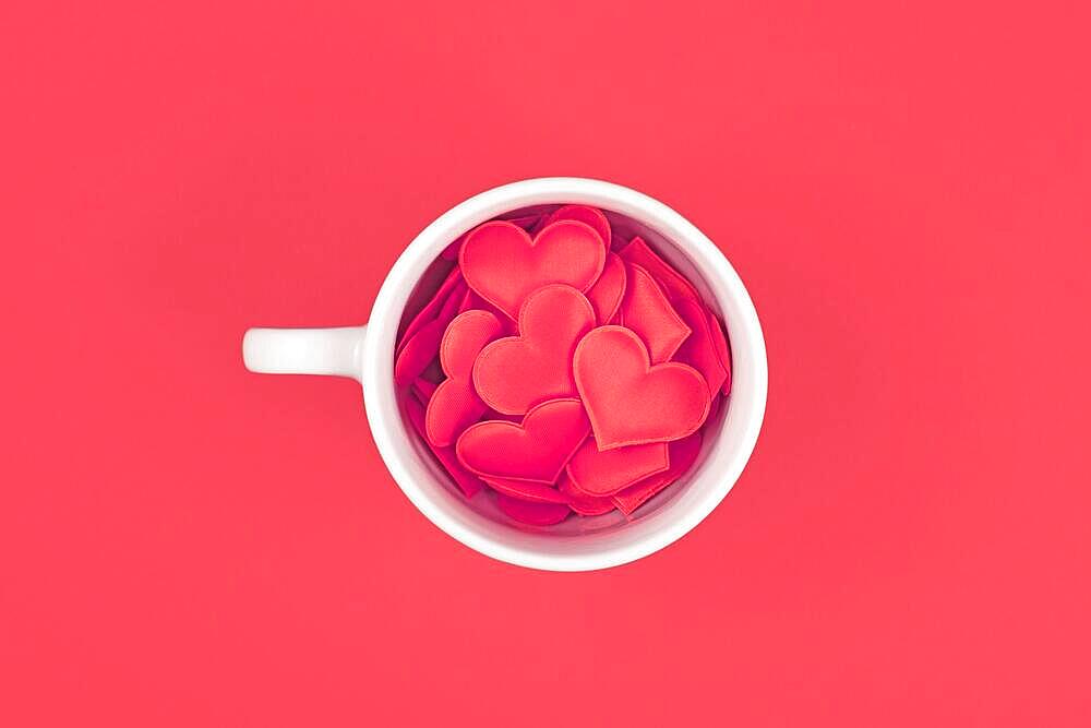 Top view of tea cup filled with red hearts