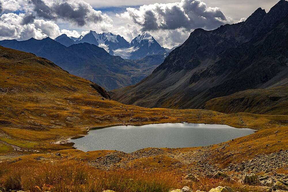 Mountain lake Lej Suvretta with Bernina group and Engadine mountains with cloudy sky, St Moritz, Engadine, Grisons, Switzerland, Europe