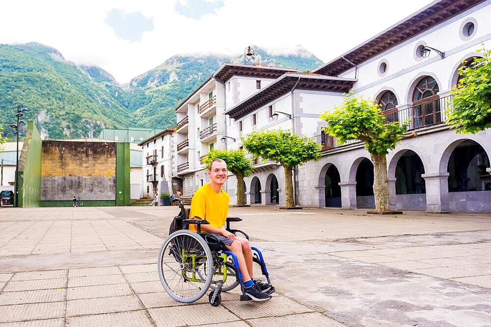 A disabled person in a wheelchair walking through the town square