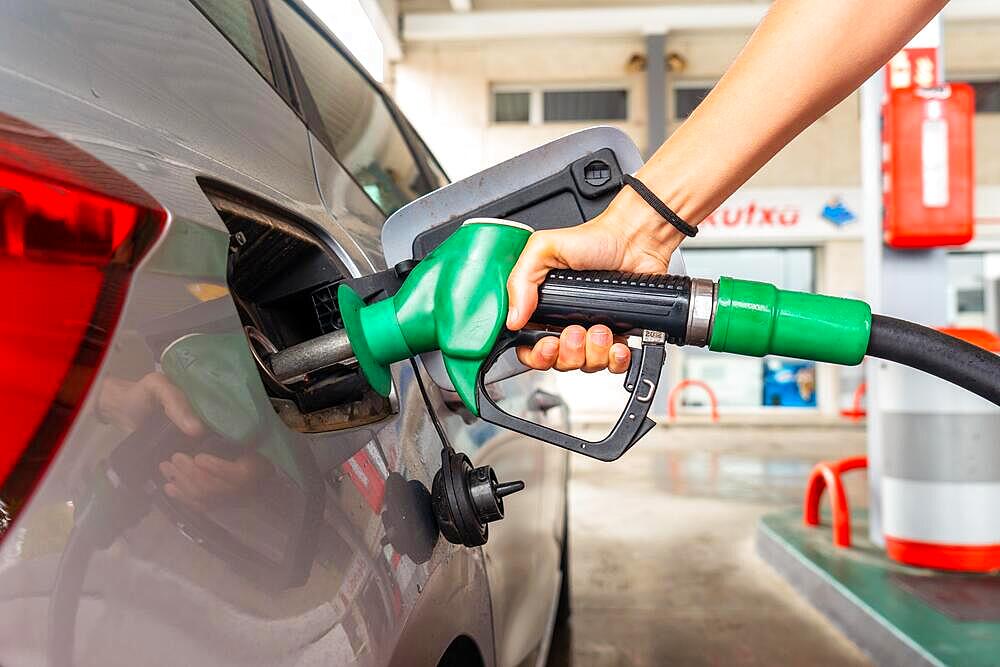 Woman refueling gasoline at the gas station in the fuel crisis with the high prices