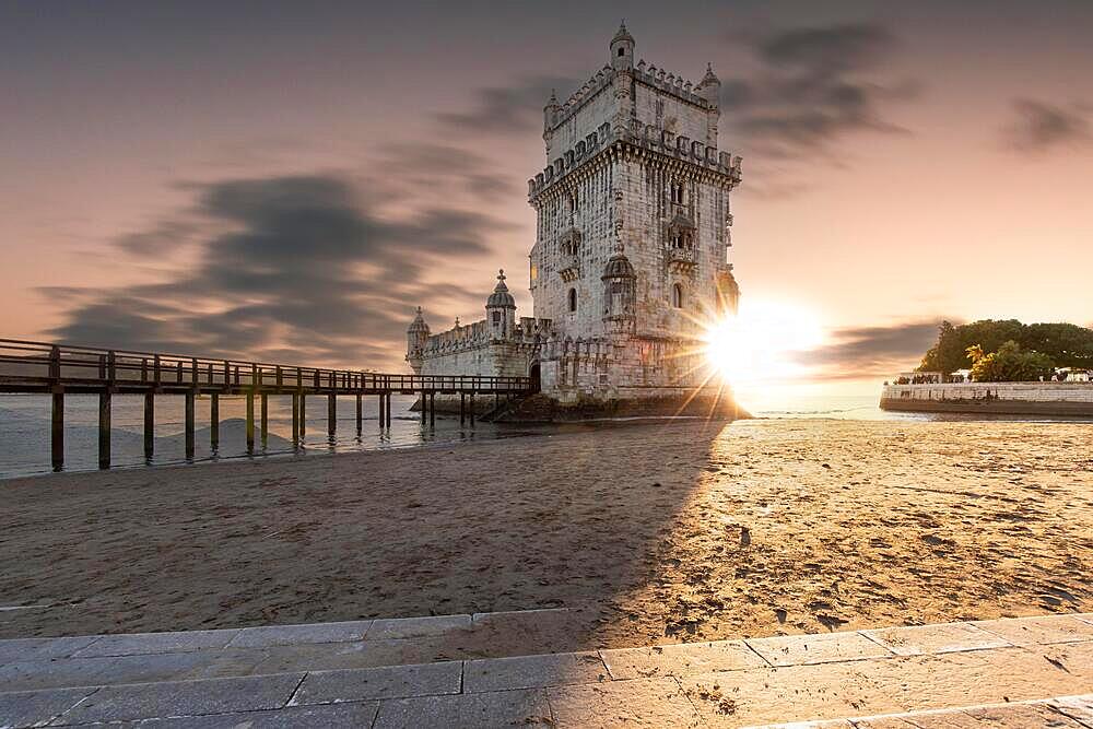 The Torre de Belem, a historic watchtower or defence defence tower built on a rock on the banks of the Tagus River, sunset in the Belem district, Lisbon Portugal