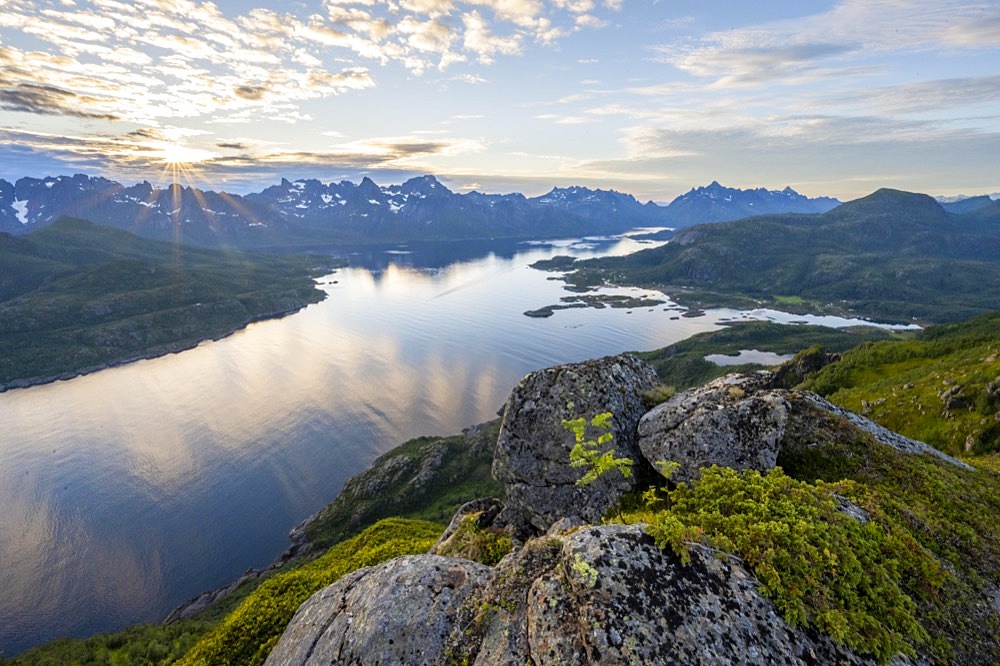 Sun star at sunset over the mountain peaks, view of fjord Raftsund and mountains, view from the top of Dronningsvarden or Stortinden, Vesteralen, Norway, Europe