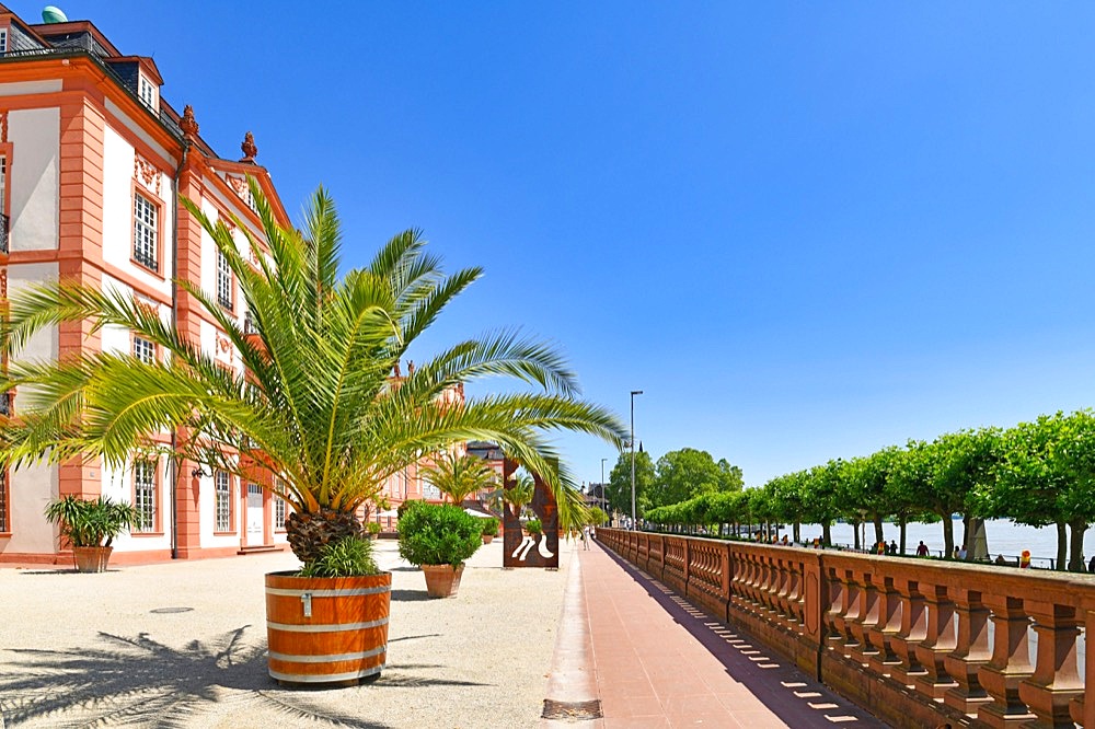 Wiesbaden, Germany, July 2021: Court of baroque palace called Schloss Biebrich with Rhine river promenade on sunny day, Europe