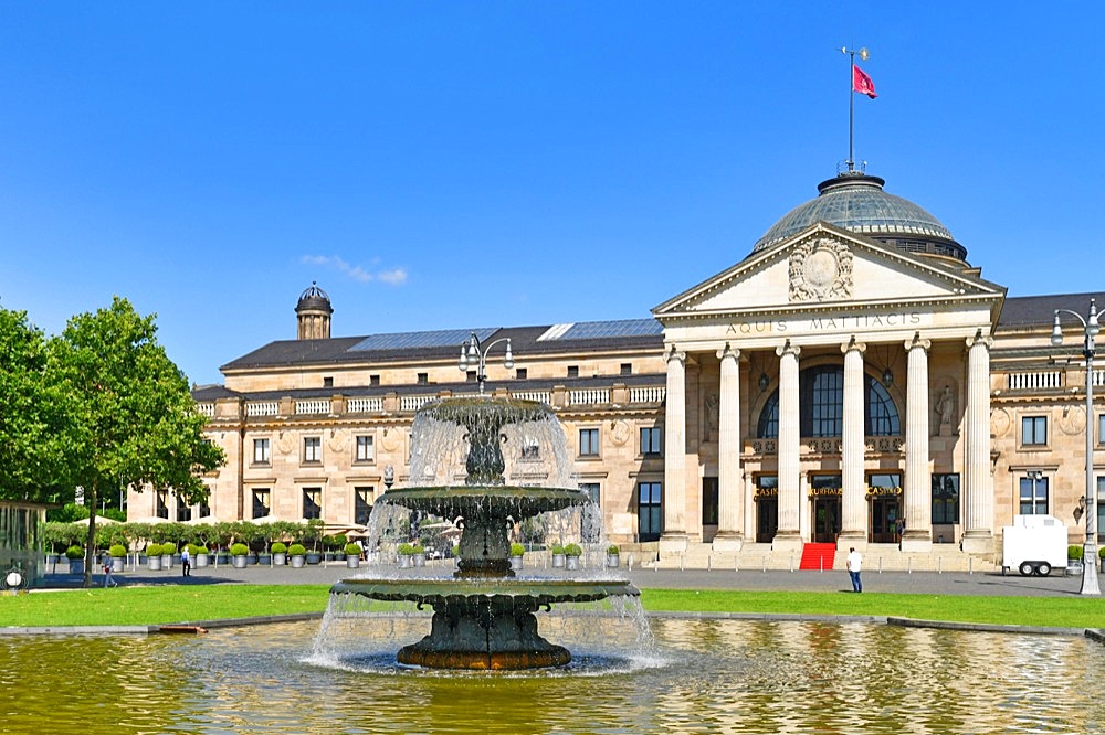 Wiesbaden, Germany, July 2021: Fountain in public park called Bowling Green in front of convention center called Kurhaus, Europe