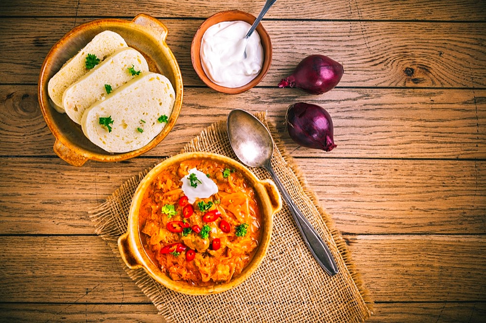 Hungarian Szegedin Goulash with pickled white cabbage (sauerkraut), onion and bread dumplings in pan