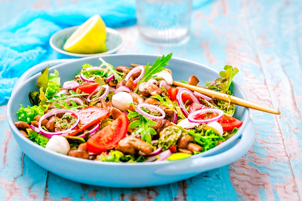 Vegetable salad with roasted champignons and mozzarella cheese with onions