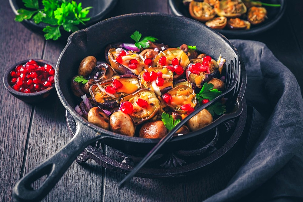 Baked small eggplants, stuffed with mushrooms and pomegranate in baking pan